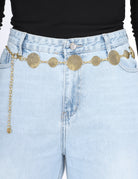 Light blue jeans with a gold chain belt featuring circular embellishments.